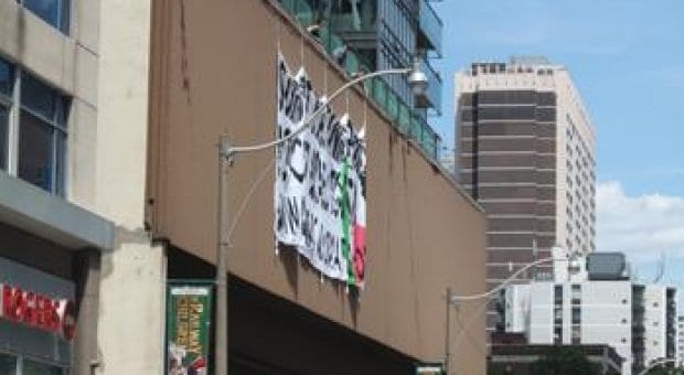 QuAIA drops banner from Wellesley subway station