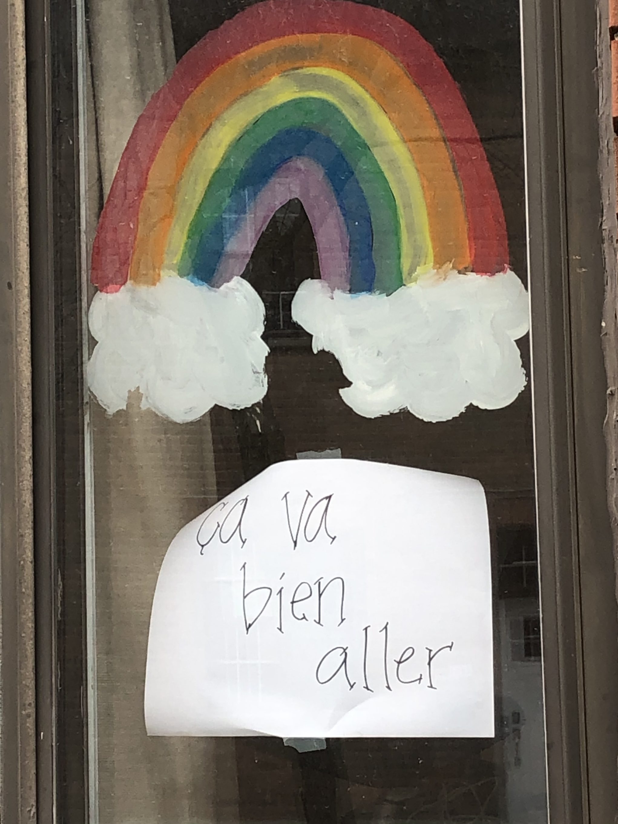 A rainbow poster in a window in Montreal.