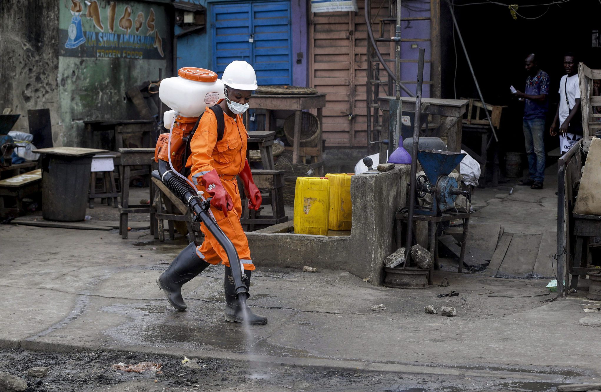 A health worker sprays disinfectant in an informal roadside market, in an attempt to halt the spread of COVID-19, in Lagos, Nigeria.