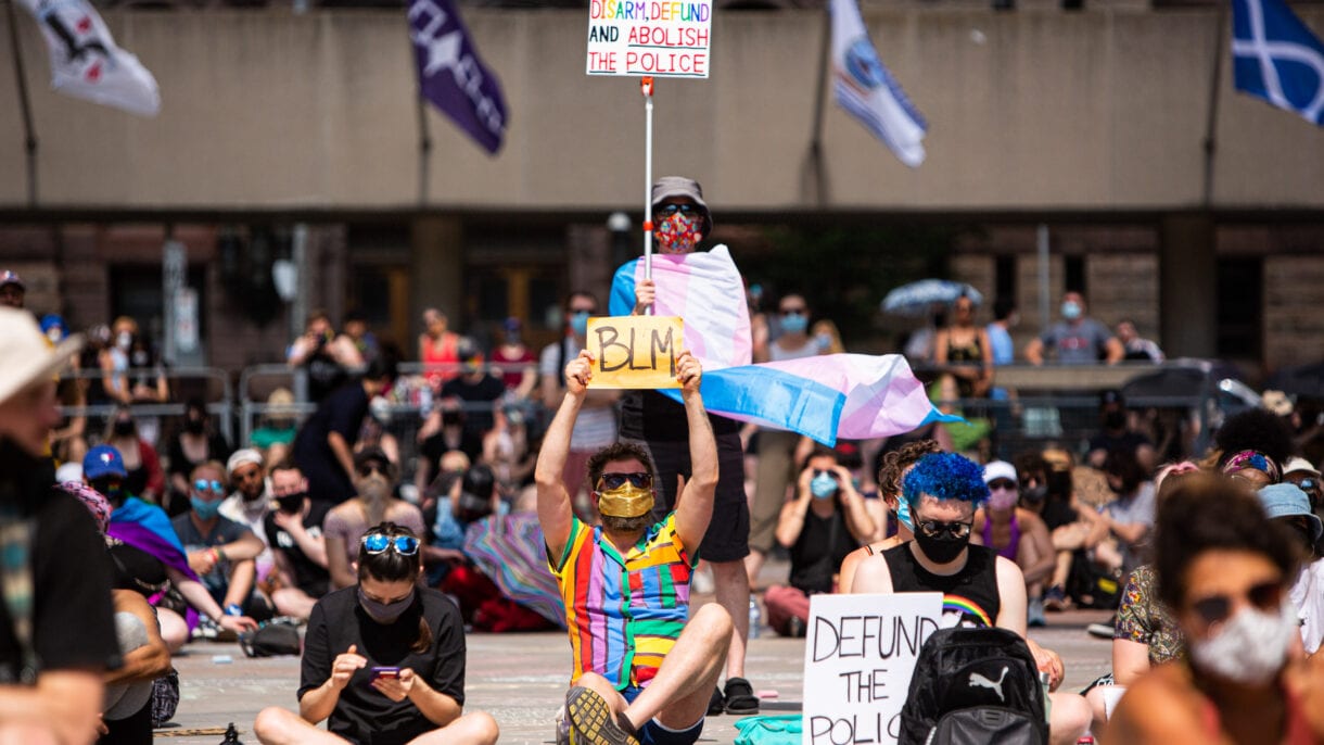 Among the protesters, visible signs state 