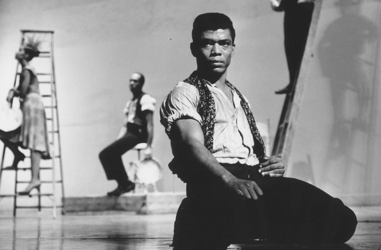 The dancer Alvin Ailey seen sitting foreground in a dance performance.