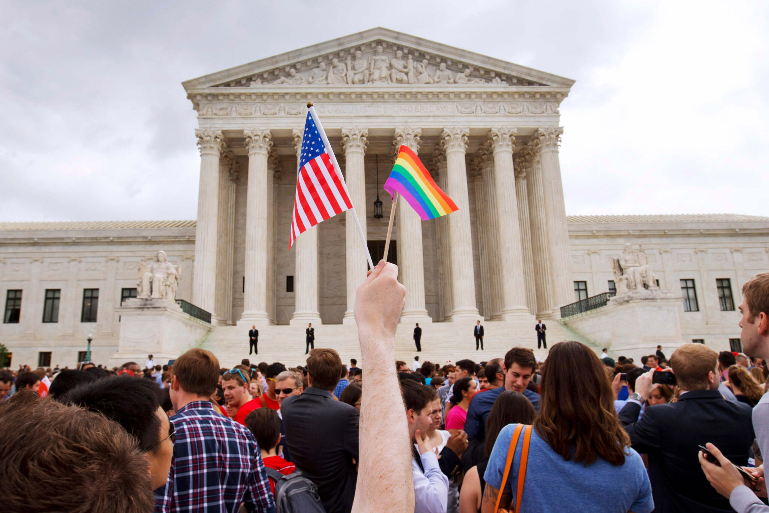 A man holds a U.S. and a rainbow flag outside the Supreme Court in Washington after the court legalized gay marriage nationwide.