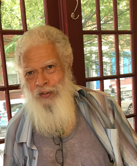A photo of Samuel R Delany sporting his signature white hair and beard.
