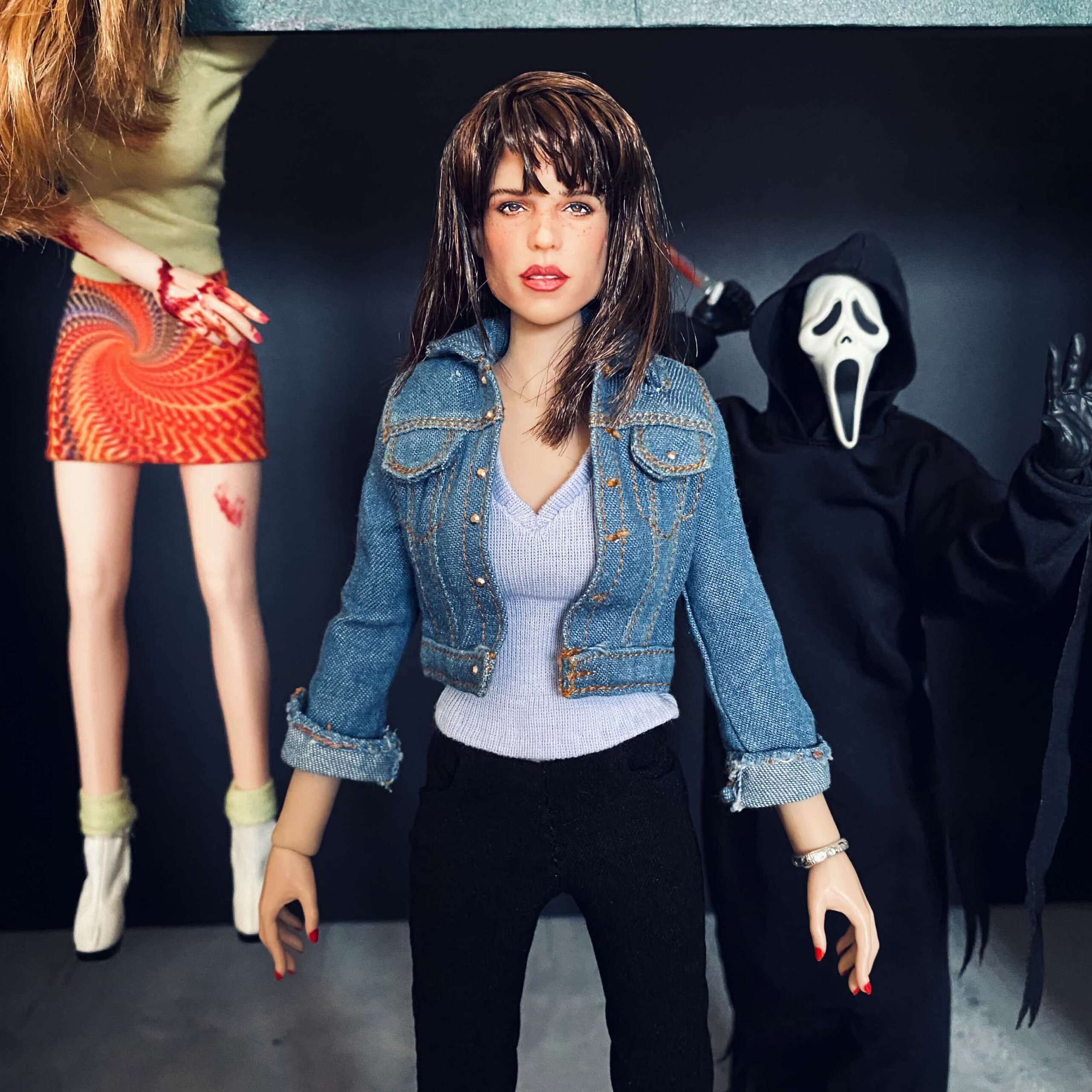 A neve campbell doll with a doll of ghostace behind her