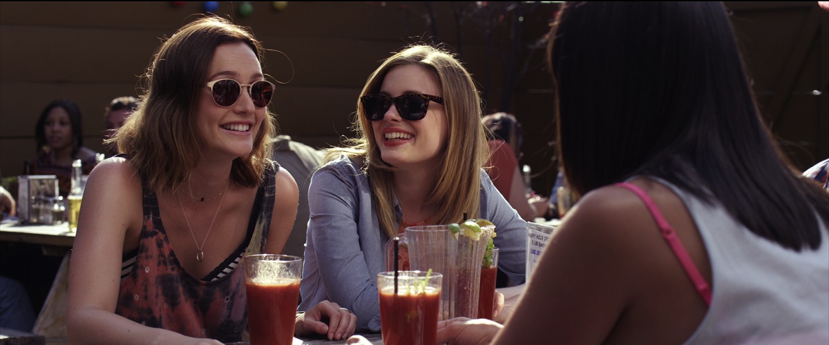 Two women in sunglasses are having a boozy brunch.