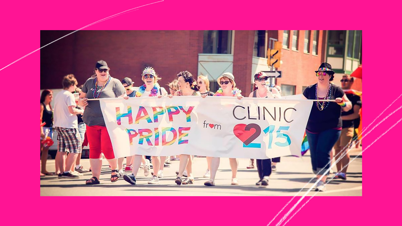 Marchers hold a sign that says "Happy Pride" and "Clinic 215"