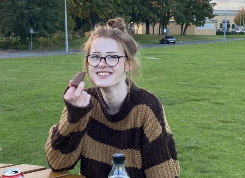 Brianna Ghey in a striped sweater and glasses in a grassy park