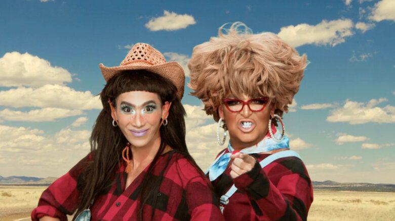 Two individuals wearing red and black plaid shirts, one with a straw hat and the other with a large blonde wig, perform in a commercial in a scene from RuPaul's Drag Race All-Stars Season 9 Episode 5 in a scene from RuPaul's Drag Race All-Stars Season 9 Episode 5.