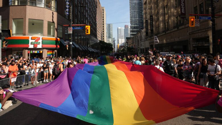 Participants carry a pride flag as they walk in the Toronto Pride Parade, on Sunday June 25, 2023.