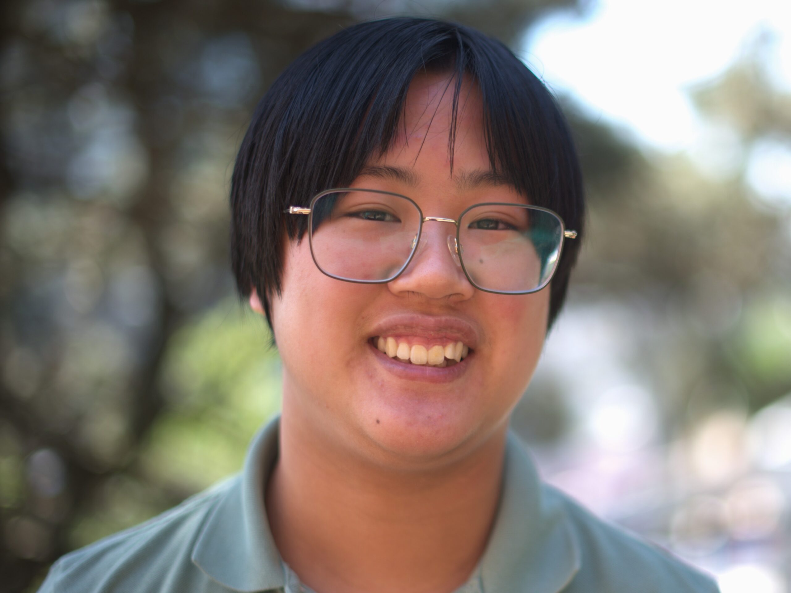 Headshot of Jacob Aron Leung in front of a blurred nature background