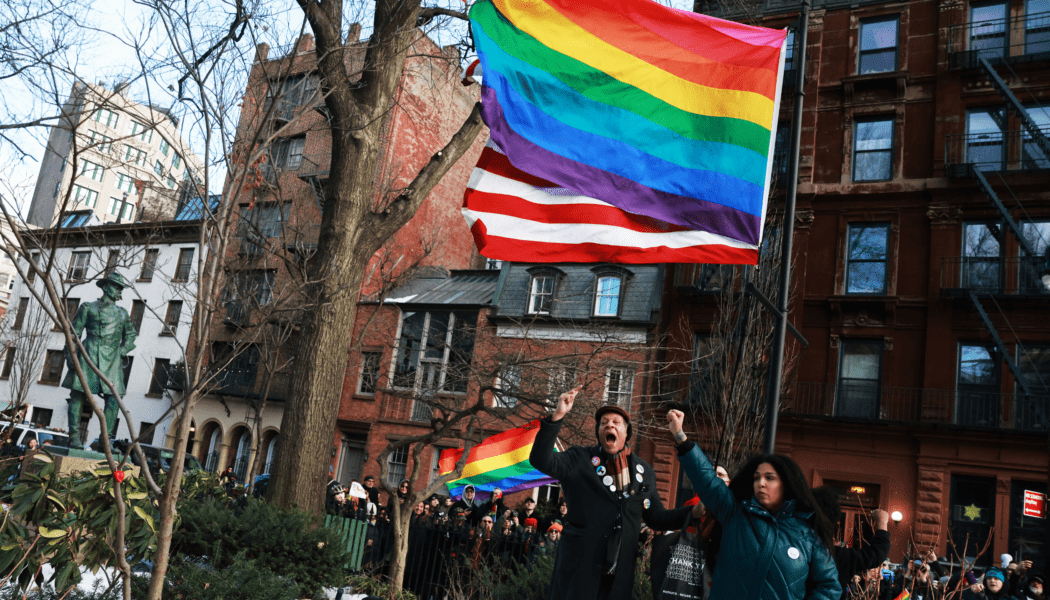 Demonstrators put up an LGBT Pride flag at Stonewall National Monument after it was removed by the Trump Administration