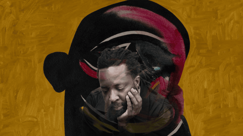 Marlon James in front of the Disappearers book cover